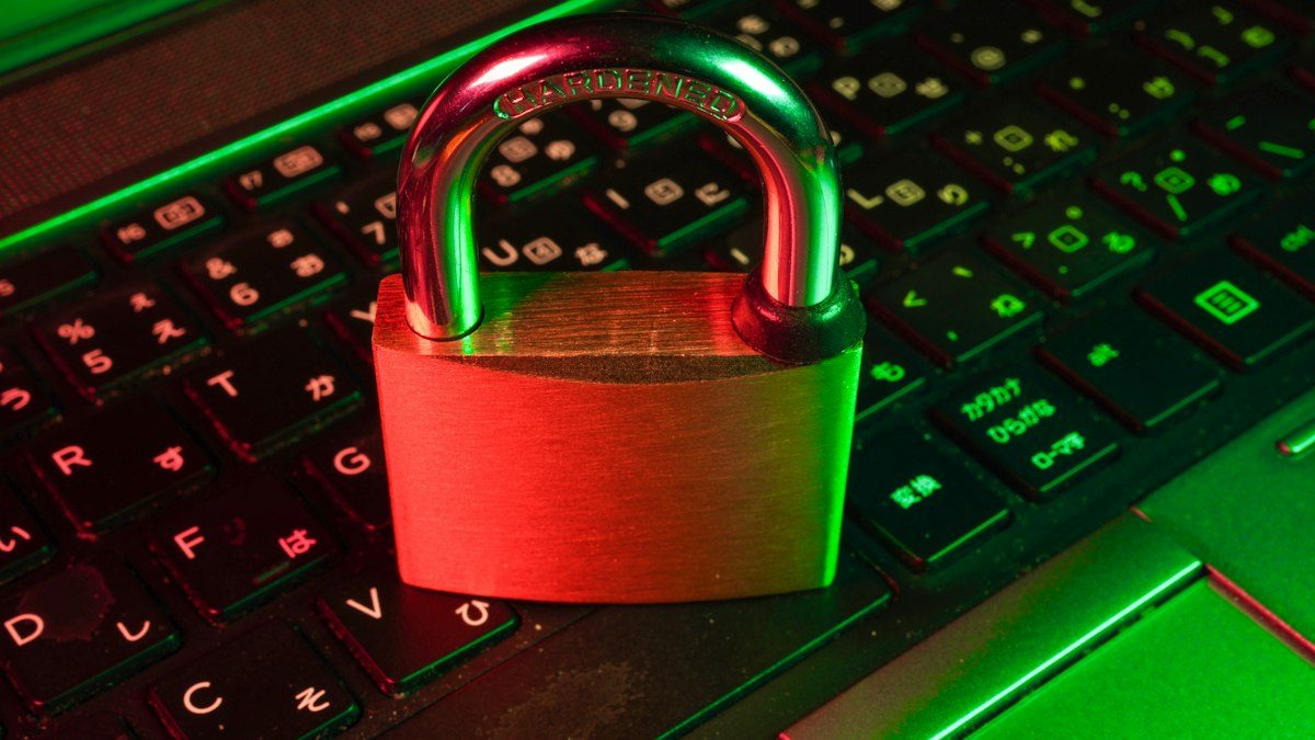 Candado rojo sobre un teclado iluminado en verde