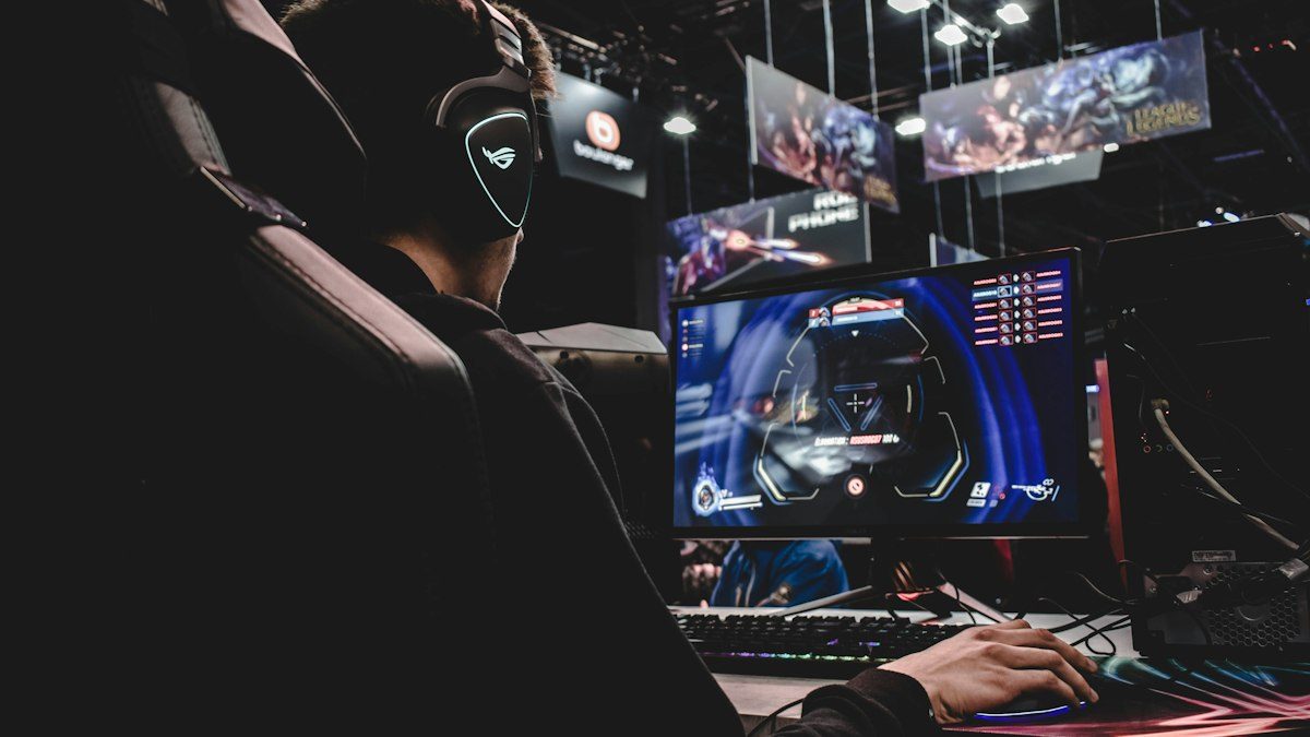 Jugador frente a varios monitores en una sala gamer