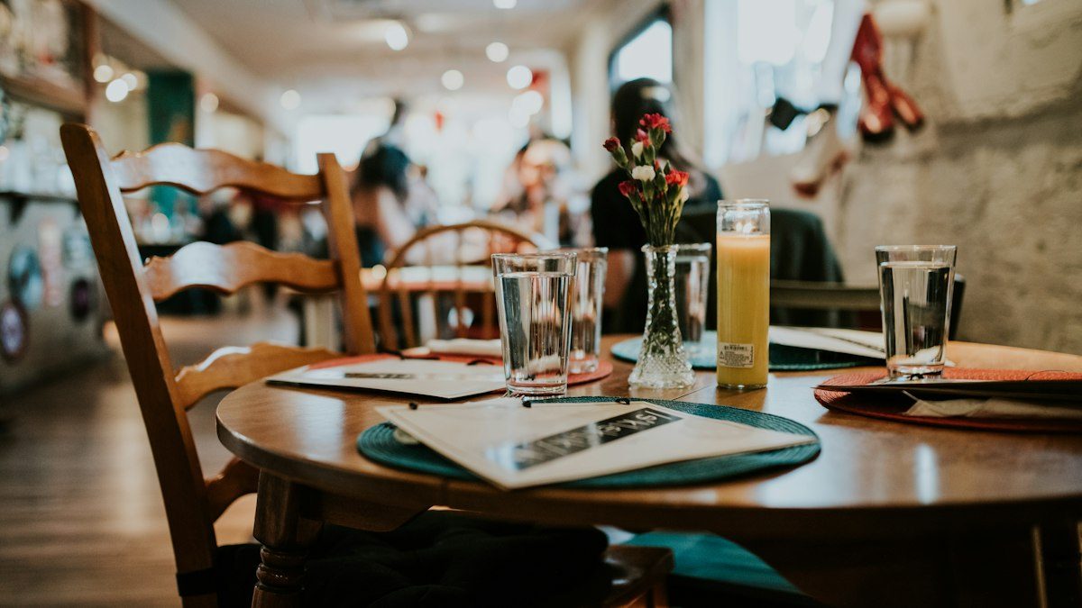 Interior de un café con mesas y clientes