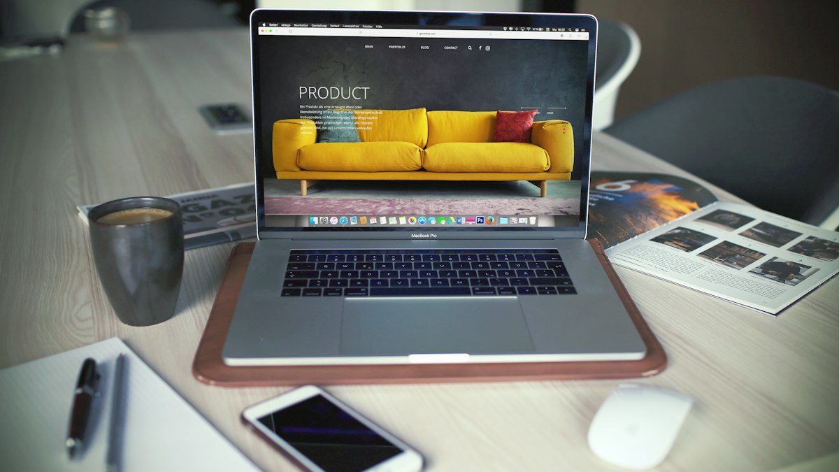 Portátil mostrando una tienda online de muebles sobre un escritorio